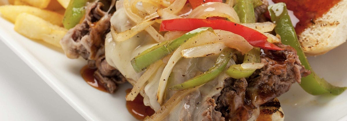 steak topped with peppers and onions