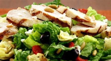 sliced grilled chicken on mediterranean salad