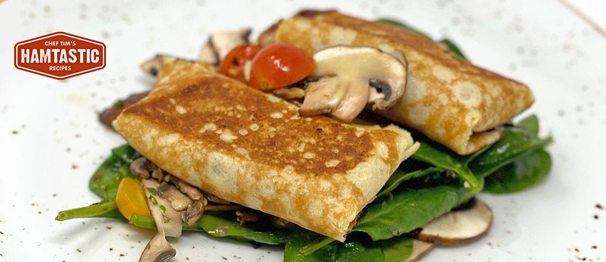 stuffed crepes on spinach with mushrooms