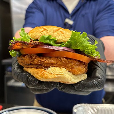 hands holding a chicken bacon sandwich