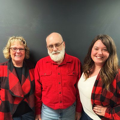 3 smiling people in red shirts