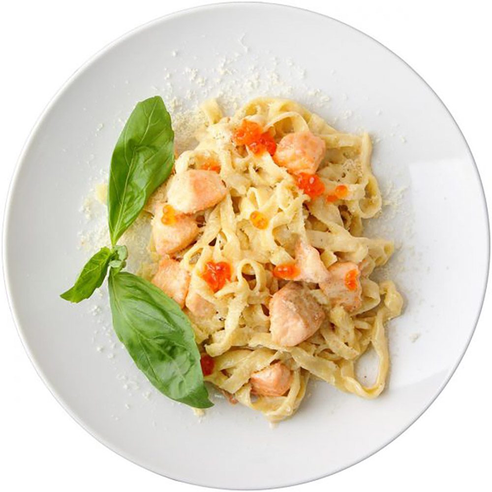 plate of dressed pasta noodles with a basil leaf garnish