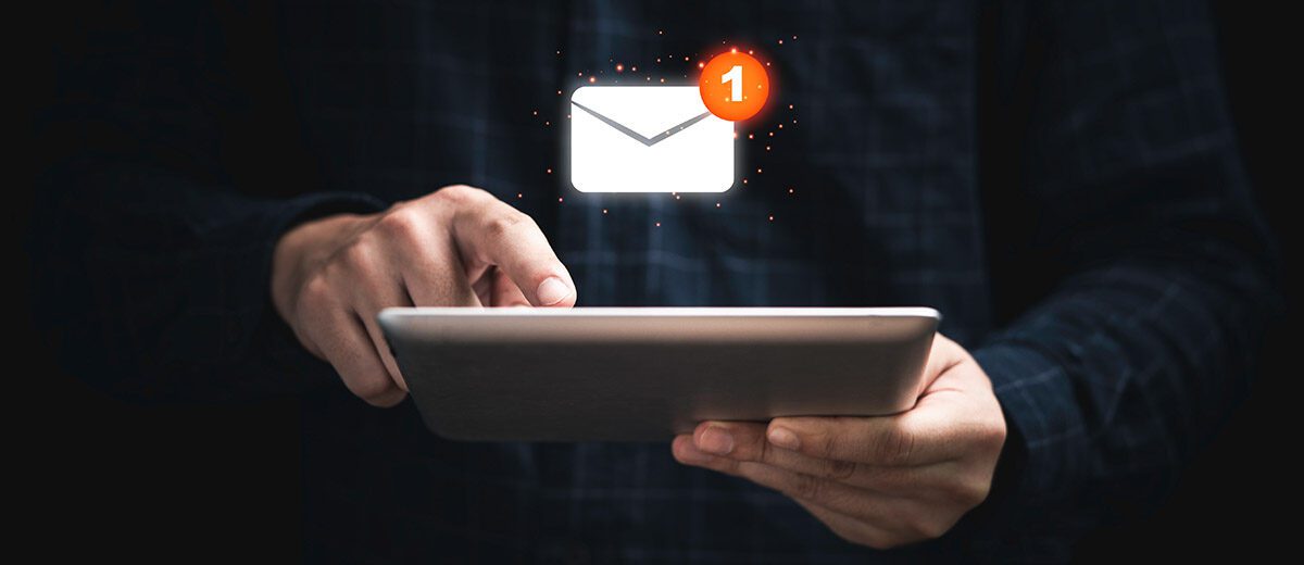 hand with an ipad and floating email icon