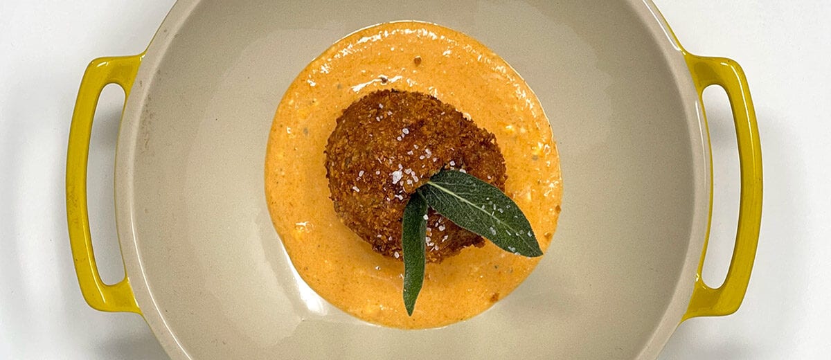 fried breaded food ball on orange sauce